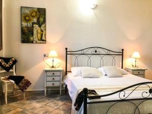 a bedroom with a bed and two night stands with lamps at Sas Tilibbas-Ammentos Posada in Posada