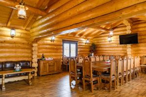 a dining room in a log cabin with a table and chairs at Cabana Nemtisor in Nemţişor