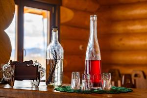 twee flessen wijn en glazen op een tafel bij Cabana Nemtisor in Nemţişor