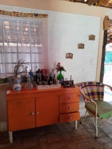 a kitchen with a wooden dresser and a chair at SITIO RUSTICO BEIRA RIO in Guararema
