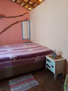a small bedroom with a bed and a table at SITIO RUSTICO BEIRA RIO in Guararema