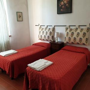 2 posti letto in camera d'albergo con lenzuola rosse di PODERE CANCELLONI a Massa Marittima