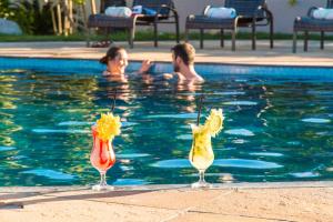 - un groupe de personnes se baignant dans une piscine dans l'établissement Novo Sol Hotel - Rede Soberano, à Porto Seguro