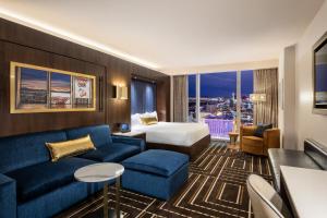 a hotel room with a couch, chairs and a television at Circa Resort & Casino - Adults Only in Las Vegas