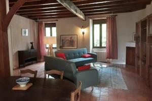 a living room with a blue couch and a table at Maison de charme confortable au cœur de la nature in Saint-André-de-Double