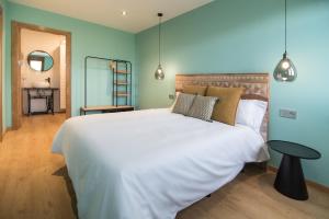 a bedroom with a large white bed and a table at AGROTURISMO ZUMINTXAZ in Mungia