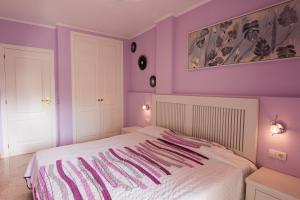 パルム・マールにあるApartamento Los Balandrosの紫の壁と白いベッドが備わるベッドルーム1室