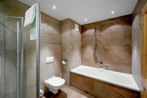a bathroom with a tub and a toilet and a shower at Top location Gerlos! - Lovely Apartment - 6P in Gerlos +41 photos