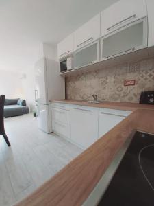 a kitchen with white cabinets and a refrigerator at Mediterran Apartman in Zalakaros