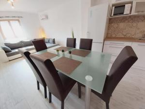 Una mesa de comedor y sillas en una sala de estar. en Mediterran Apartman, en Zalakaros