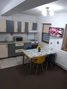 a kitchen with a table and chairs in a room at Vila Lavinia in Buşteni