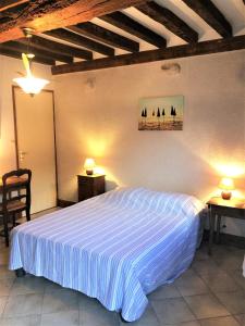 een slaapkamer met een bed en twee tafels en twee lampen bij Maison 2 chambres avec espace extérieur privé et petit-déjeuner en supplément - fait-maison et produits locaux in Vierville-sur-Mer