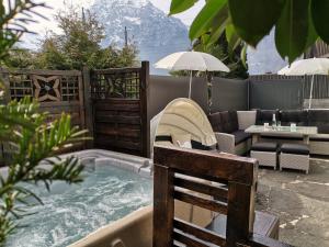 a backyard with a hot tub with a chair and a table at San Marco Vip in Fluelen