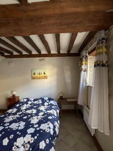 a bedroom with a bed and a wooden ceiling at Maison 2 chambres avec espace extérieur privé et petit-déjeuner en supplément - fait-maison et produits locaux in Vierville-sur-Mer