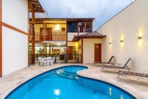 una piscina en medio de una casa en Suítes Trilha do Sol, en Ubatuba