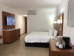 Cozumel Hotel & Resort TM by Wyndham All Inclusive في كوزوميل: غرفة فندقية بسرير كبير وطاولة