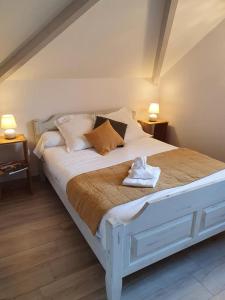 - un lit blanc dans une chambre avec deux lampes dans l'établissement Cottage La Grenouillère, à Menetou-Râtel