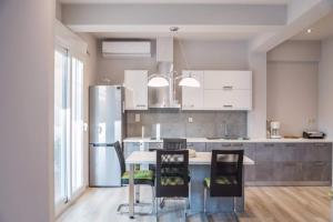 a kitchen with a refrigerator and a table with chairs at Athena Apartments in Vitalades