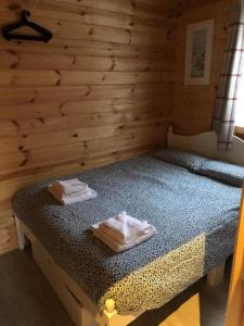 1 dormitorio con 1 cama con 2 toallas en Bacchus Hotel Log Cabins en Sutton on Sea