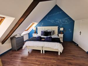 1 dormitorio con 1 cama grande y pared azul en Domaine de Kérizel, en Ambon