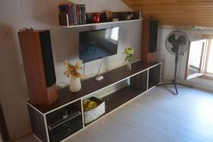 a living room with a flat screen tv on a wall at Apartman Bernardica in Bol