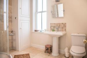 a bathroom with a toilet and a sink and a window at Tower House, Aldeburgh in Aldeburgh +27 photos