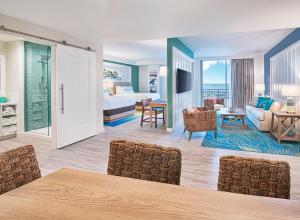 ジャクソンビル・ビーチにあるMargaritaville Jacksonville Beachのベッドとリビングルームが備わるホテルルームです。