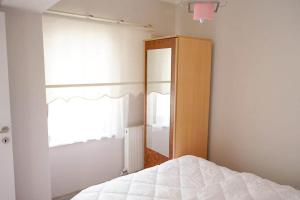 1 dormitorio con cama, espejo y ventana en Ören Konak Apart Otel, en Burhaniye