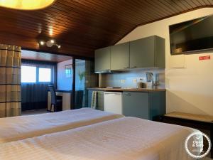 sypialnia z łóżkiem i małą kuchnią w obiekcie Discovery Apartment Carnaxide w mieście Carnaxide