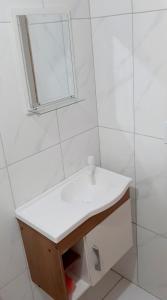 a bathroom with a white sink and a mirror at Casa Jasmim arraial do cabo in Arraial do Cabo