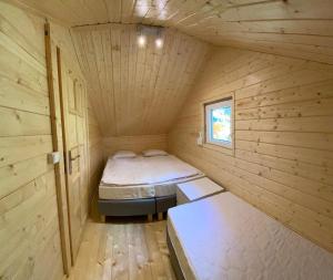 Kleines Zimmer mit 2 Betten in einer Holzhütte in der Unterkunft Wakacyjne domki Wieleń in Wielen Zaobrzanski