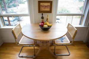 a wooden table with a bowl of fruit and two chairs at Object Hotel 2BR Room 2A in Bisbee