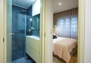 a bedroom with a glass shower and a bed at ChillHouse_Porto - Praça da República in Porto +29 photos