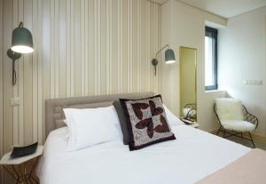 a bedroom with a white bed with a pillow on it at ChillHouse_Porto - Praça da República in Porto