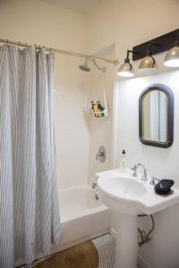 a bathroom with a sink and a tub and a shower curtain at Object Hotel 1BR Room 3A in Bisbee