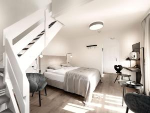 a white bedroom with a bed and a staircase at Berg-Leben in Grossarl