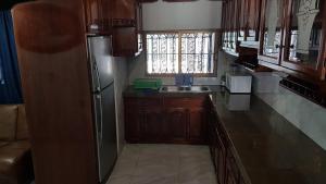 uma cozinha com armários de madeira e um frigorífico de aço inoxidável em Casa amueblada - Mazatlán em Mazatlán