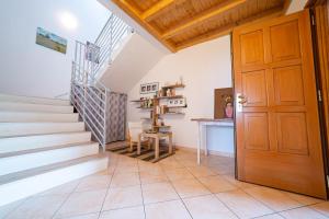 escalera en una habitación con puerta de madera en Le Muse, Comano Terme Holiday - piano terra, en Comano Terme
