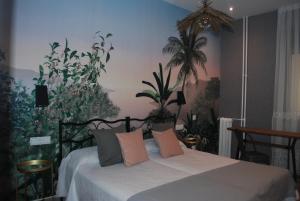 a bedroom with a bed with plants on the wall at Hostal Avenida in Madrid
