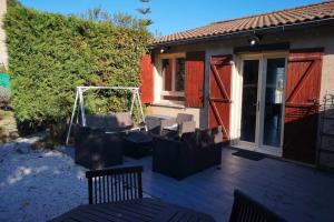 a patio with two chairs and a swing at Jolie petite Maison de Charme dans quartier boisé in Vallauris