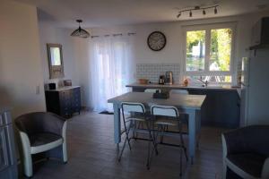 a kitchen with a table and chairs in a kitchen at Jolie petite Maison de Charme dans quartier boisé in Vallauris