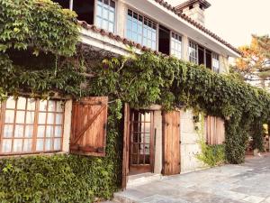 an ivy covered building with wooden doors and windows at Casa Fenteiras in Cangas de Morrazo