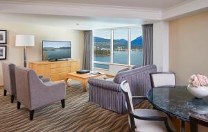 a living room filled with furniture and a tv at Pan Pacific Vancouver in Vancouver