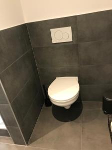 ein weißes WC im Bad mit schwarzen Fliesen in der Unterkunft Apartment Stockholm, top renoviert, 35qm, Köln nah in Bergisch Gladbach + 6 Fotos