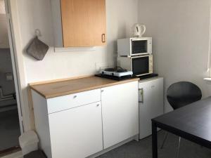 a small kitchen with a microwave and a counter top at Bed & Bath tæt på Nationalpark Vadehavet in Ribe