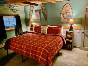 um quarto com uma cama com um cobertor xadrez vermelho em Grunberg Haus Inn & Cabins em Waterbury