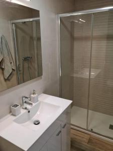 y baño blanco con lavabo y ducha. en Apartamento acogedor en Granada, en Granada