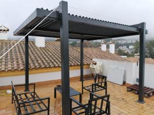 a patio with two chairs and a roof at El Bosque, tu entrada a la Sierra Gaditana. in El Bosque