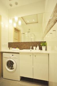 a bathroom with a washing machine and a sink at Grand-Tourist Center Point Apartments in Gdańsk