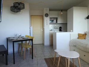 Il comprend une cuisine et un salon avec une table et des chaises. dans l'établissement Bel appt T2 4p confortable avec vue mer imprenable, à Narbonne-Plage